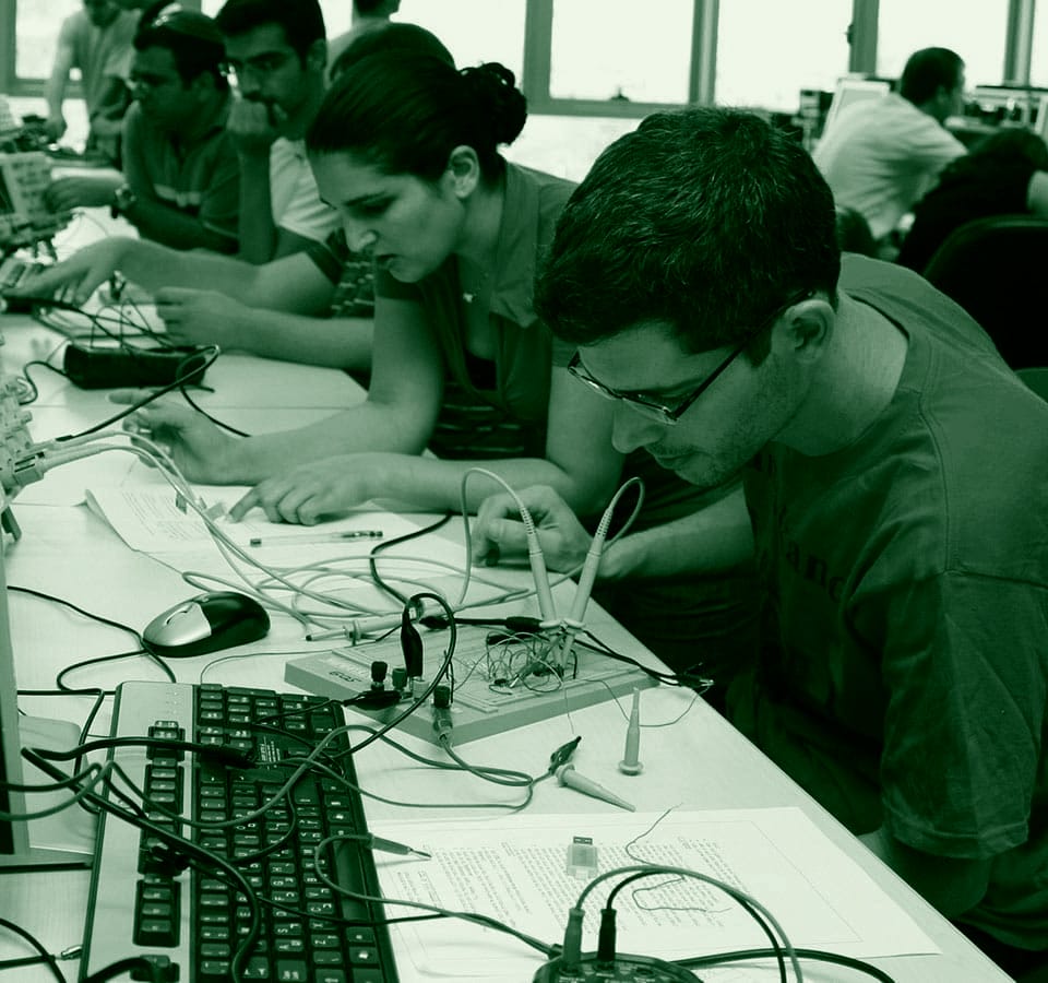 Students work on electronics projects in a classroom.